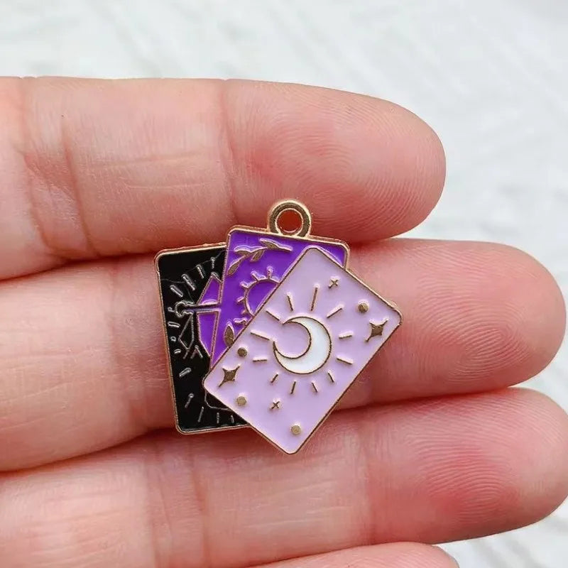 Three layered tarot charms featuring black, purple, and pink translucent stones with celestial symbols