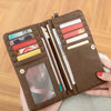 A brown retro long wallet with a double zipper holds various cards and documents.