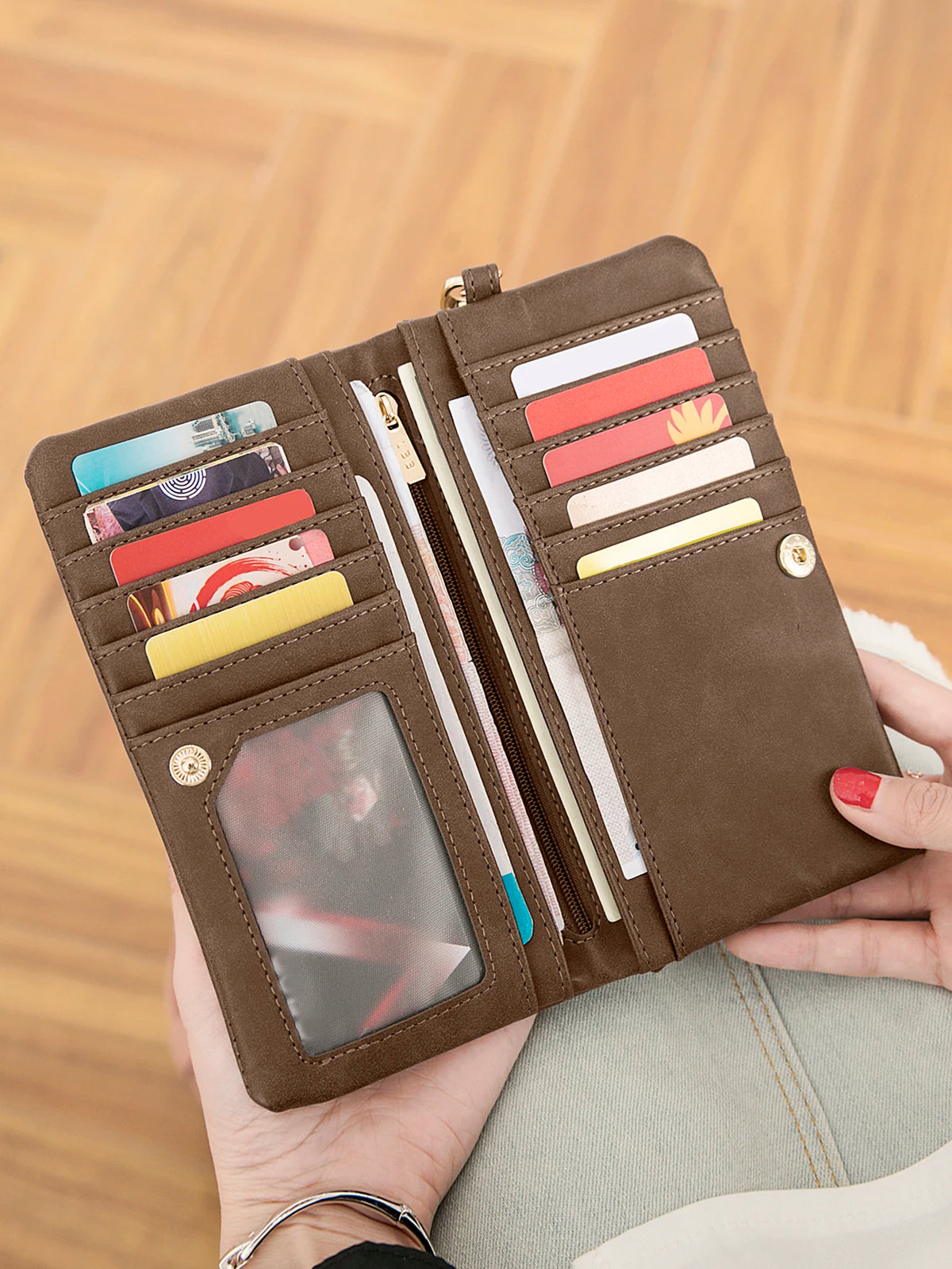 A brown retro long wallet with a double zipper holds various cards and documents.