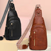 A brown PU leather crossbody sling bag with a patterned strap is displayed on a white surface.