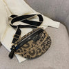 Sac bandoulière noir et or à imprimé léopard, présenté sur fond blanc.