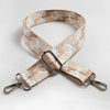 A beige and white patterned fabric strap for a crossbody bag featuring an adjustable buckle.