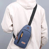 A beige hooded jacket is shown wearing a navy blue lightweight oxford cloth crossbody bag on the chest.
