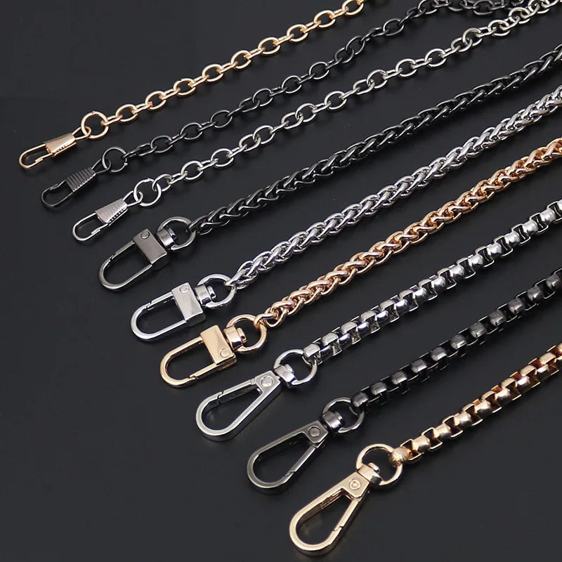 Multiple stainless steel diamond-cut curb chains of varying lengths and finishes displayed on a dark background.