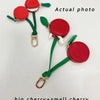 A pair of red cherry fruit shape coin purse keychains featuring a big and small cherry design on green cord.