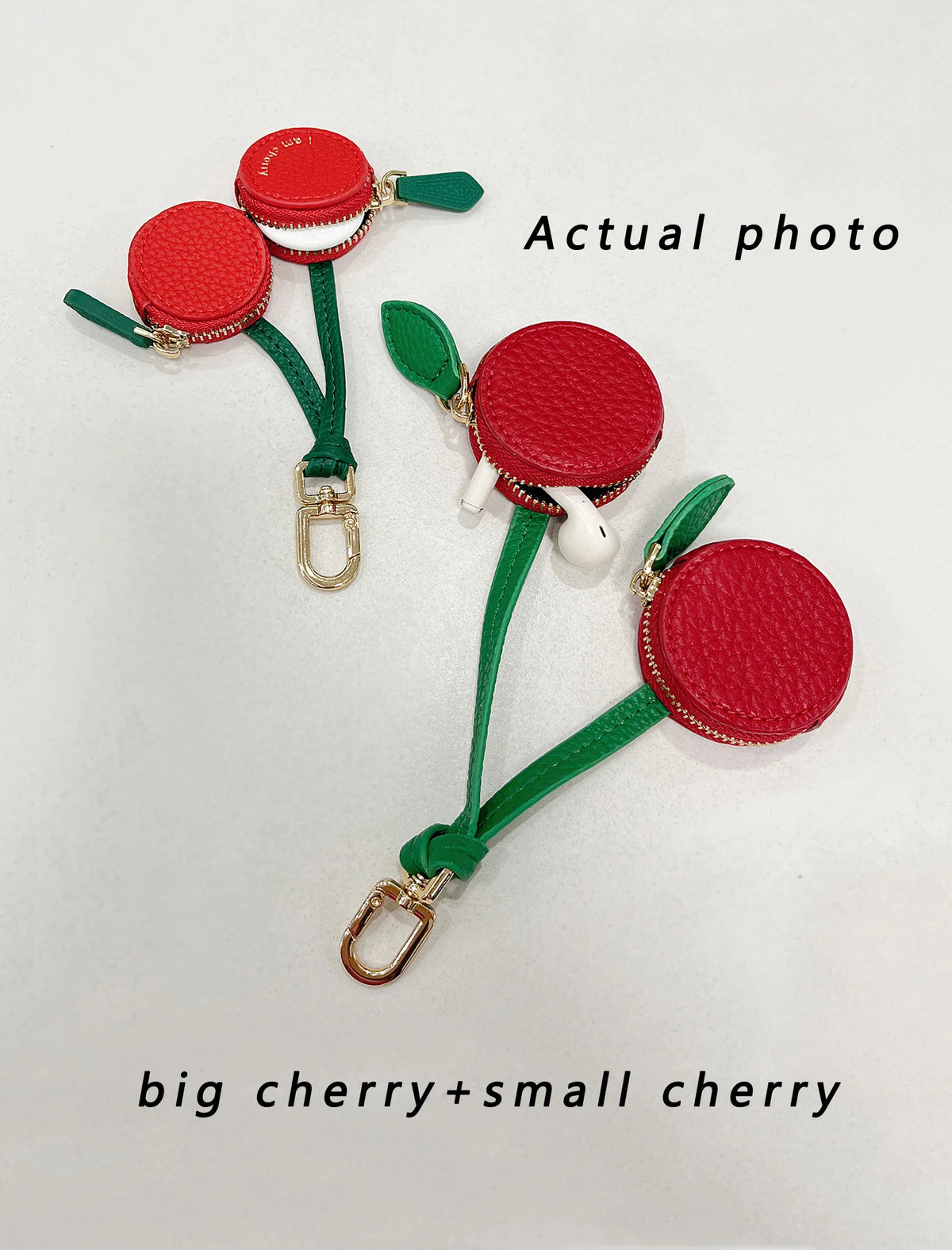 A pair of red cherry fruit shape coin purse keychains featuring a big and small cherry design on green cord.