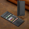 A black multi-card wallet with a leather cover and a phone grip stand resting on a brown surface.
