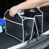 A hand is placing a black multi-pocket car trunk organizer with a foldable design into a vehicle's trunk.