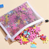 A clear mesh zipper pouch filled with colorful puzzle pieces and small plastic blocks.