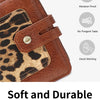 A close-up of a brown leopard print leather bi-fold wallet with a stitched closure.