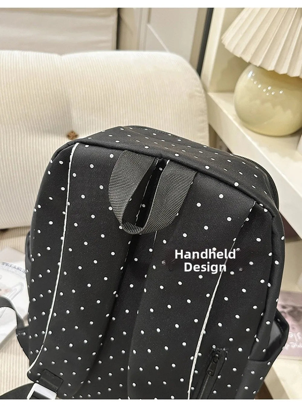 Sac à dos à pois noirs en gros plan sur fond rayé.