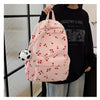 A pink corduroy fashion backpack with a patterned fabric and a white panda charm is worn by a person.