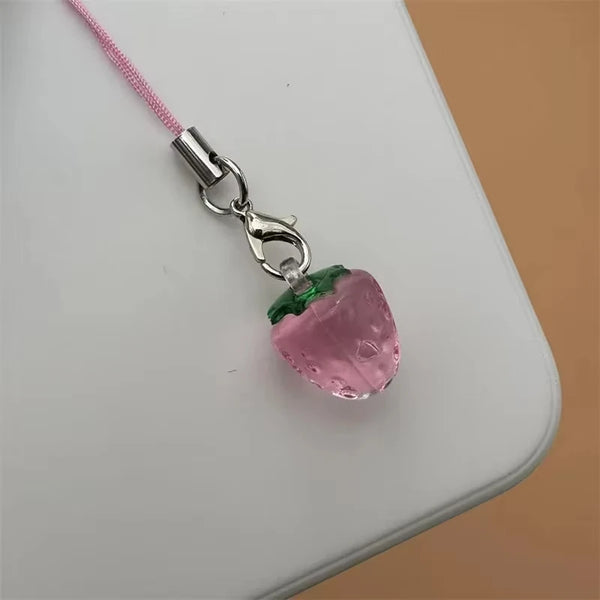 A pink strawberry resin charm attached to a silver-colored keychain with a pink cord.