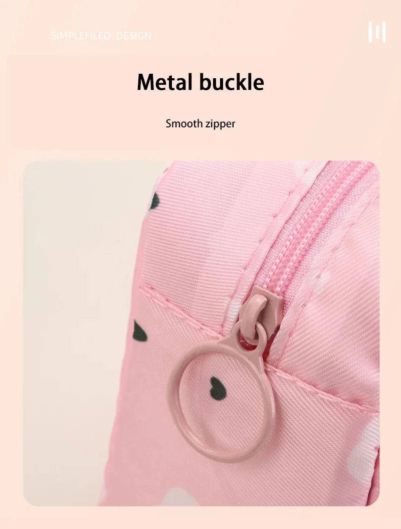 Close-up of a pink fabric pouch with a metal buckle closure and a smooth zipper detail.