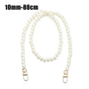 A strand of white pearls used as a strap for a handbag or purse.