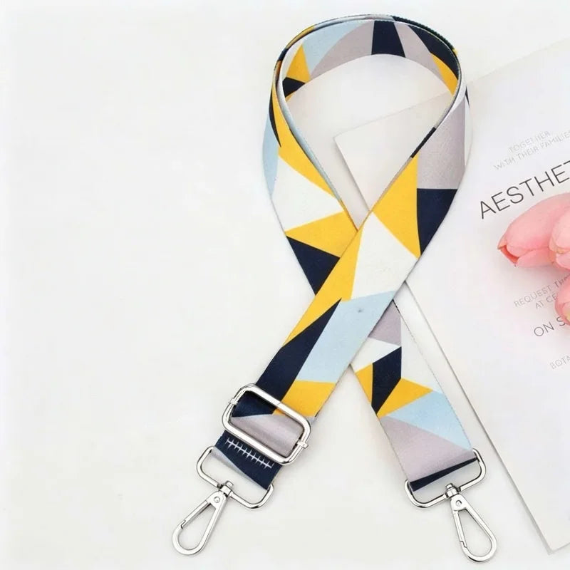 A patterned adjustable crossbody strap featuring geometric shapes in gray, yellow, and blue.