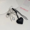 Silver and black heart-shaped key chain bag charms hanging from a silver hoop.