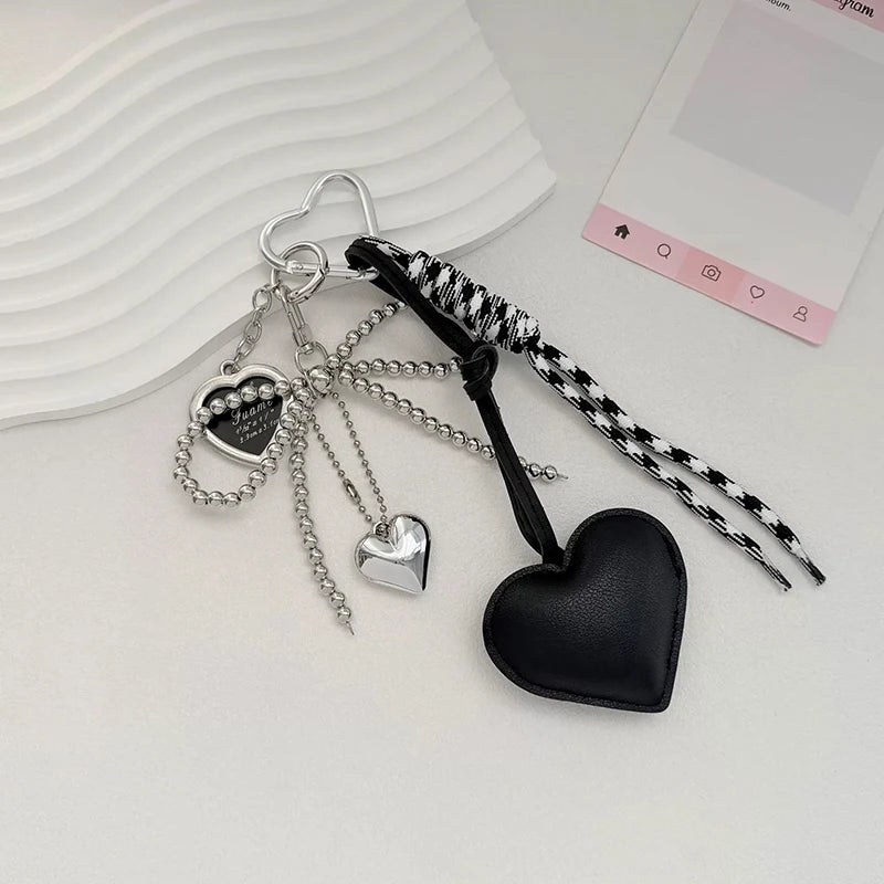 Silver and black heart-shaped key chain bag charms hanging from a silver hoop.