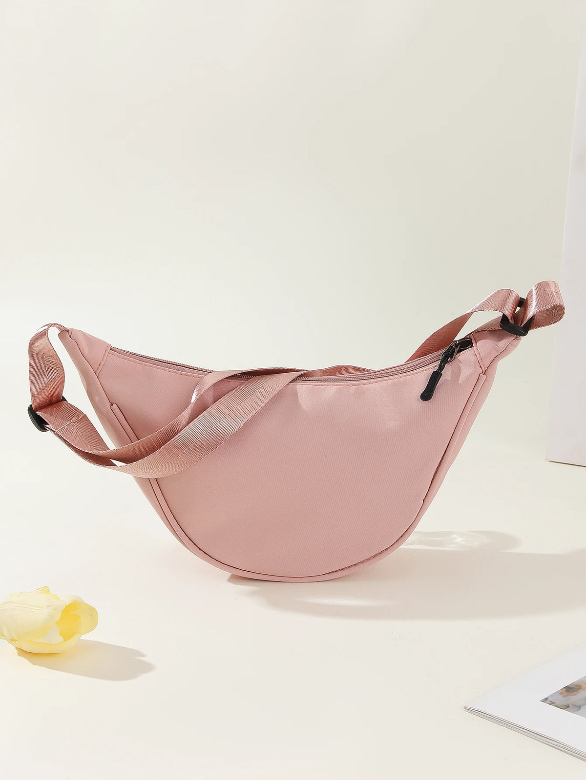 A light pink women's preppy sling crossbody bag is shown against a white background.