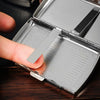 A hand opens a compact metal cigarette case, revealing a compartment for cigarettes.