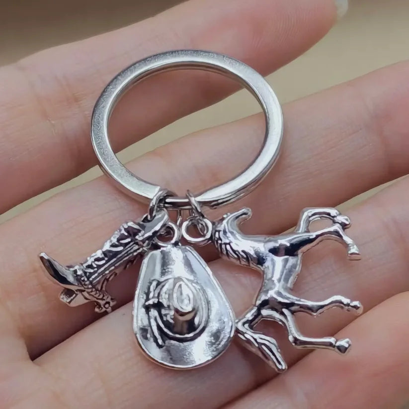 Silver keychain set featuring a cowboy boot, hat, and horse silhouette charms