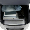 A gray laptop backpack is open, showing a padded sleeve, a tablet, and some papers inside.