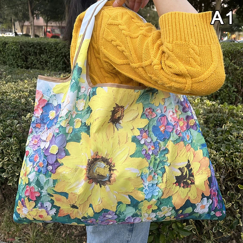 A person holds a yellow knitted sweater and carries a colorful floral print nylon shopping tote bag.
