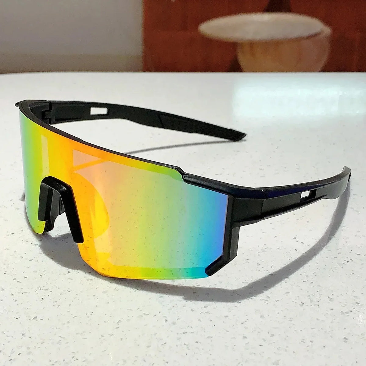 A pair of lightweight, oversized sunglasses with a vibrant gradient lens displaying yellow, green, and blue colors.