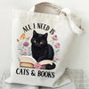 A white canvas tote bag featuring a black cat and butterfly design with the text Cats & Books printed on it.