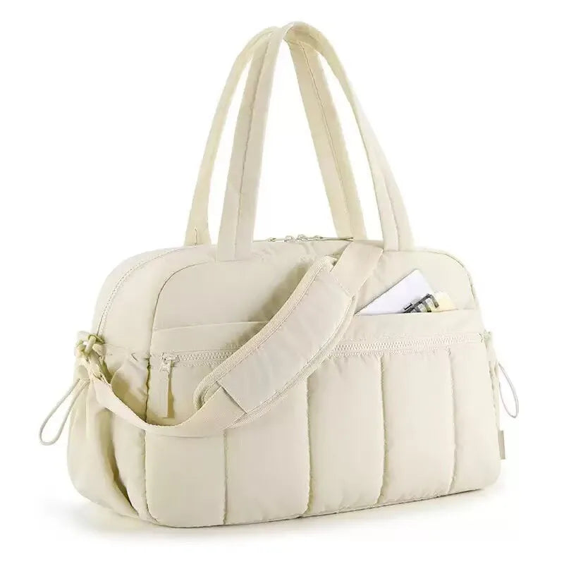 A cream-colored versatile large capacity travel and fitness bag with padded straps.
