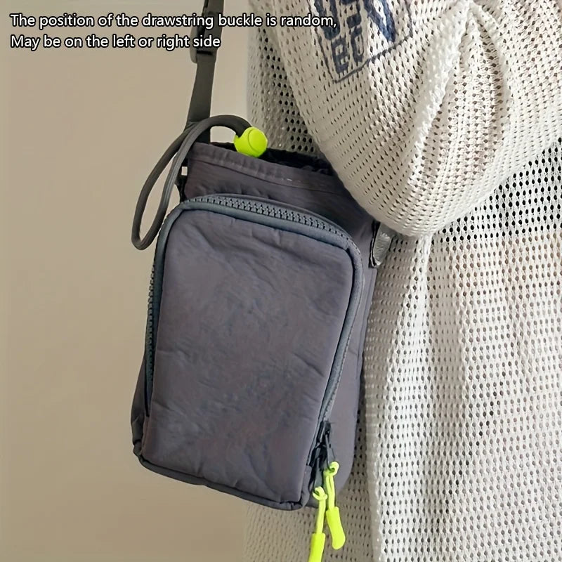 A dark gray adjustable water bottle carrier bag with a zippered pocket is shown hanging from a light-colored coat.