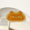 A golden caramel cat plush pencil pouch resting on a white surface.