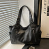 A black leather everyday large-capacity shoulder tote bag is shown against a white background.