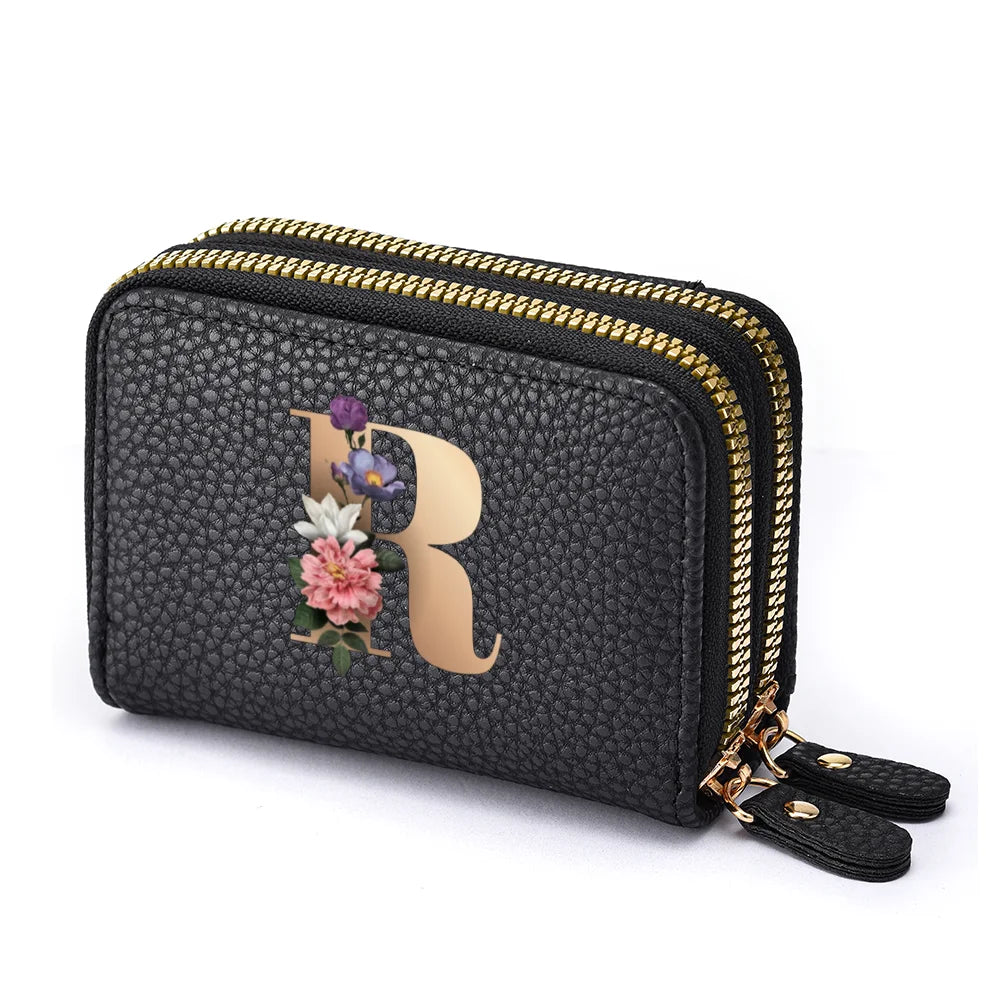 Black mini wallet with a gold zipper featuring a rose and purple flower letter print