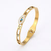 Gold cuff bracelet featuring an evil eye crystal design with blue accents.