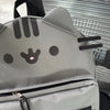 A gray Pusheen cat canvas backpack with black stripes and facial features, shown from the front.
