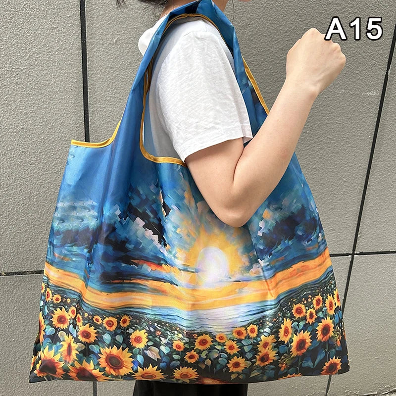 A woman holds a blue and orange floral print nylon shopping tote with a shoulder strap against a gray background.