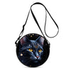 A round black crossbody bag featuring a detailed illustration of a fierce black cat's face.