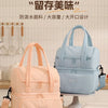 A light blue insulated lunch bag is displayed on a white stand next to a pink version, emphasizing waterproof material and de