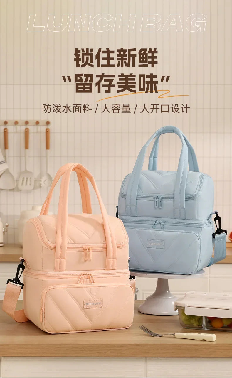 A light blue insulated lunch bag is displayed on a white stand next to a pink version, emphasizing waterproof material and de
