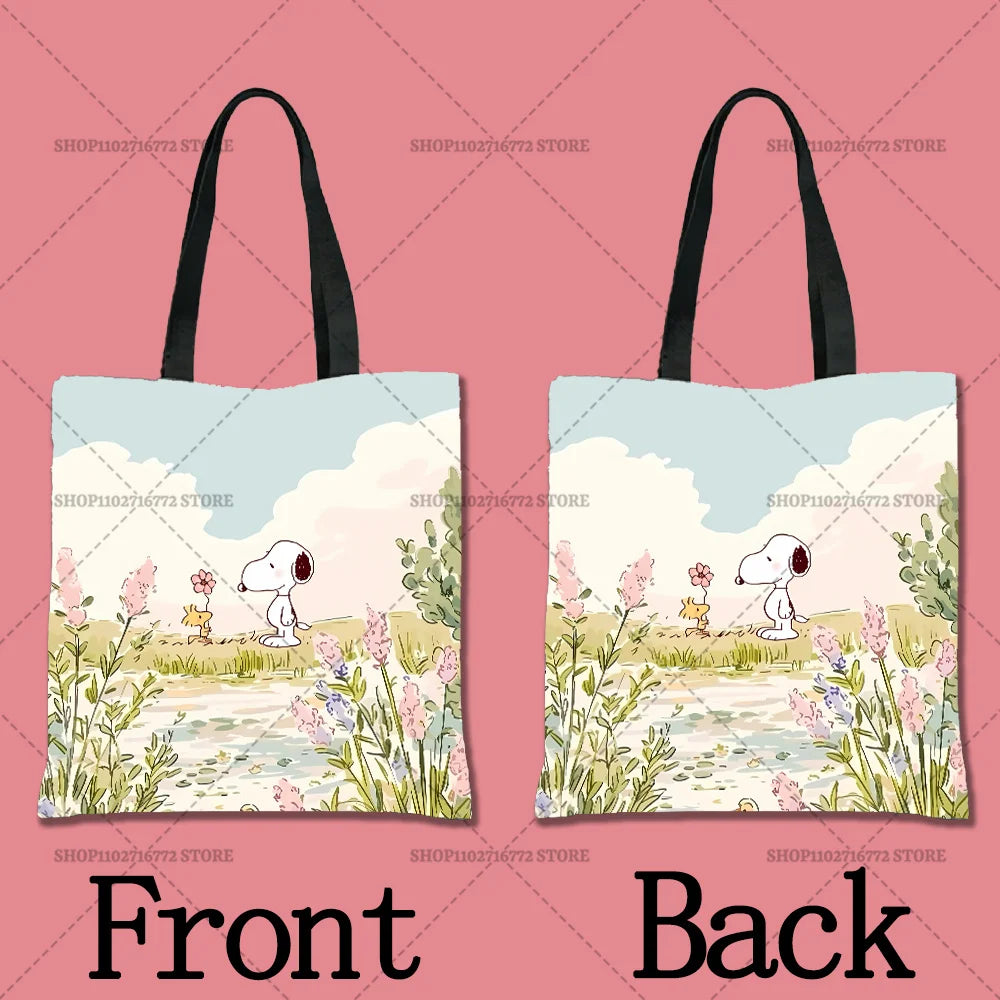 A light blue cartoon illustration of Snoopy on a tote bag, featuring pink flowers and greenery.