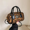 Braun-schwarze Leopardenmuster-Designer-Hobo-Tasche mit schwarzen Ledergriffen und goldfarbenem Zierwerk.