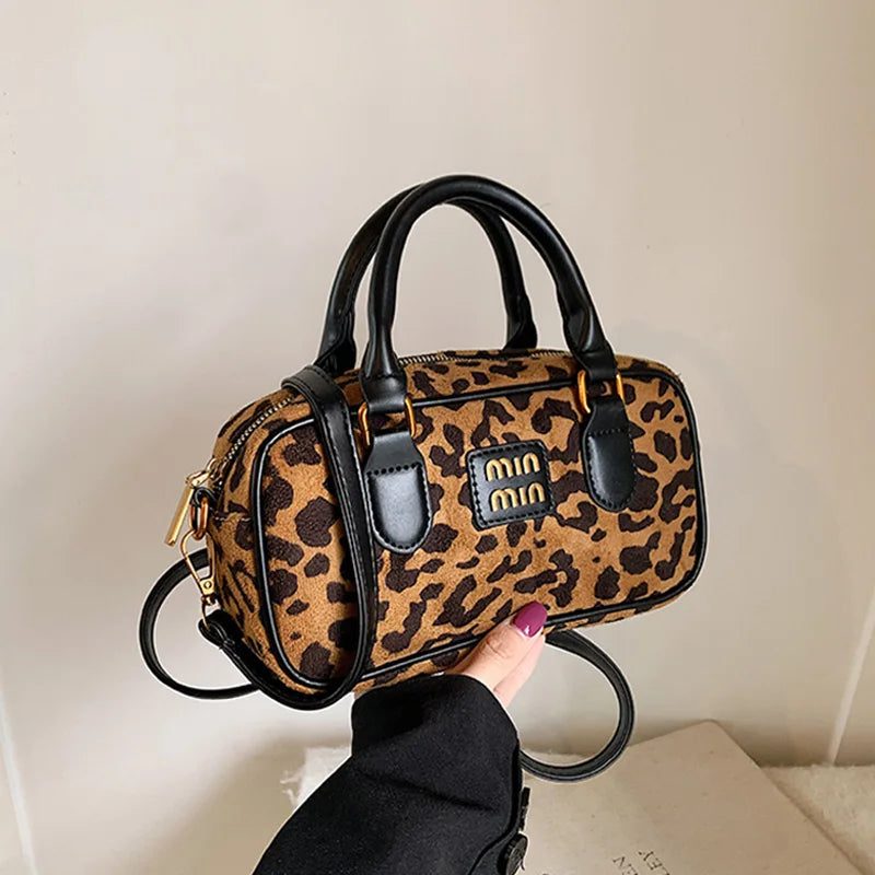 Braun-schwarze Leopardenmuster-Designer-Hobo-Tasche mit schwarzen Ledergriffen und goldfarbenem Zierwerk.
