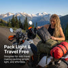 A woman is packing vacuum storage bags onto a motorcycle for travel.