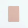 A plain, light pink PU leather passport holder with stitched edges.