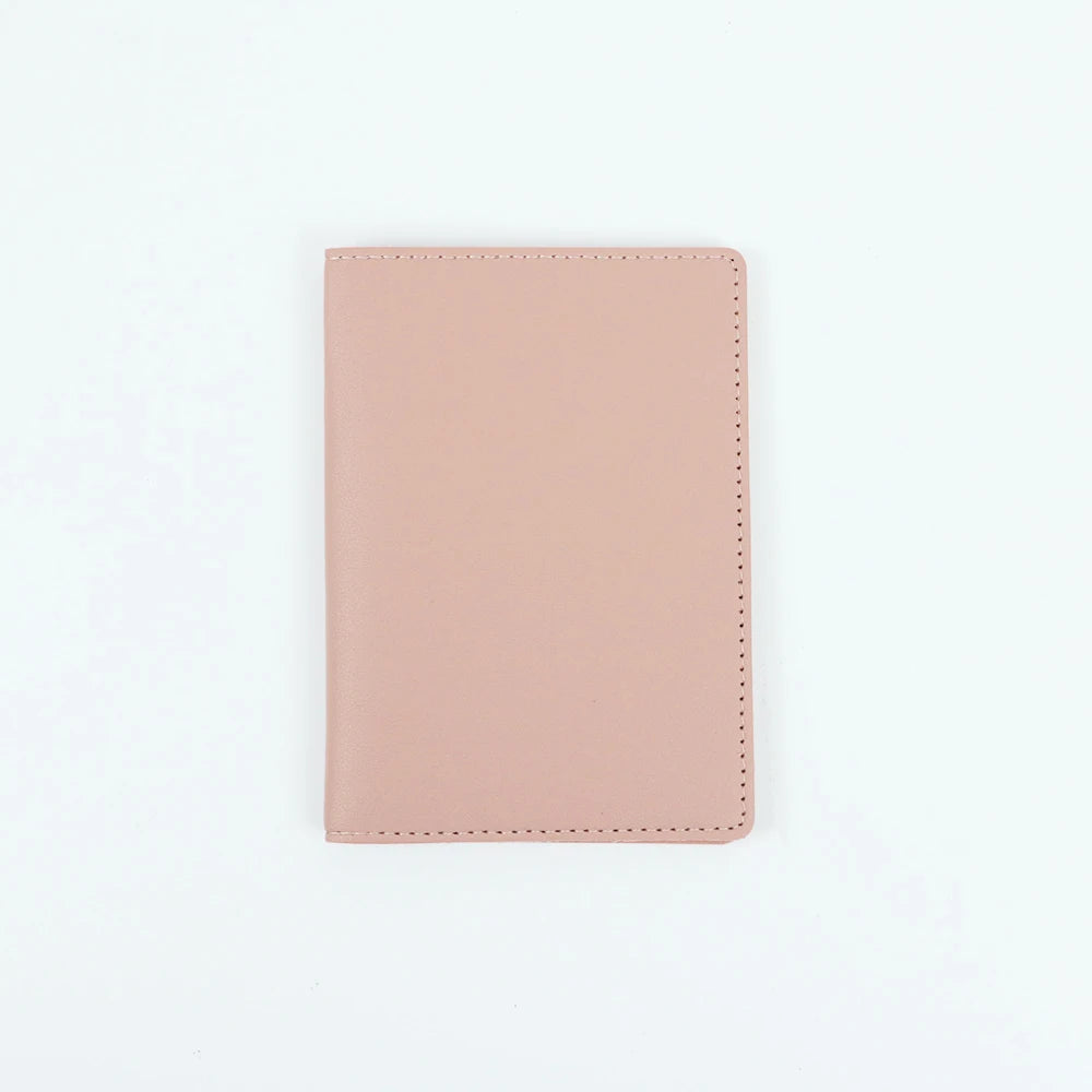 A plain, light pink PU leather passport holder with stitched edges.