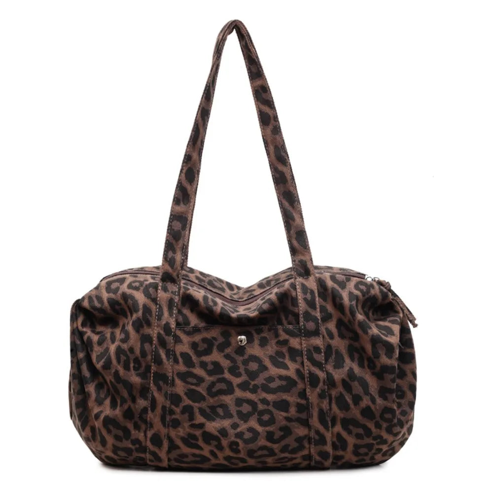 A brown leopard print canvas tote bag with an adjustable shoulder strap.