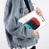 A person holds a double-layered flip pen case with a black pen and a red gaming controller on a white background.