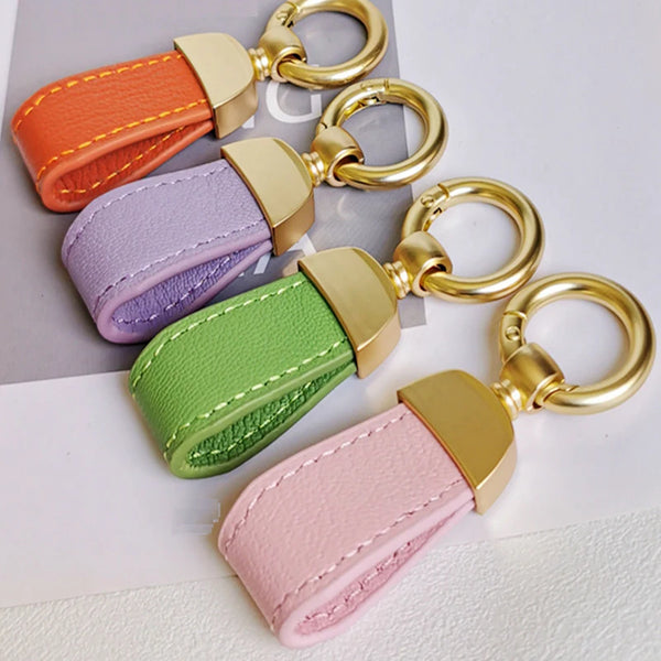 A set of five genuine leather sheepskin car key chains in various pastel colors and gold-toned hardware.