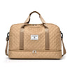 A beige durable nylon travel duffle bag with tan straps and a square label on the front.